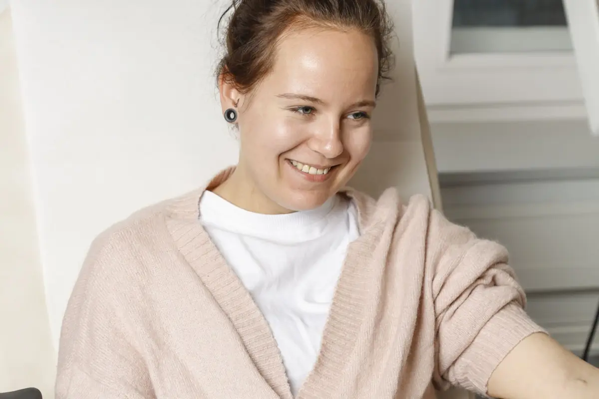 Eine junge Frau lächelt in die Kamera.