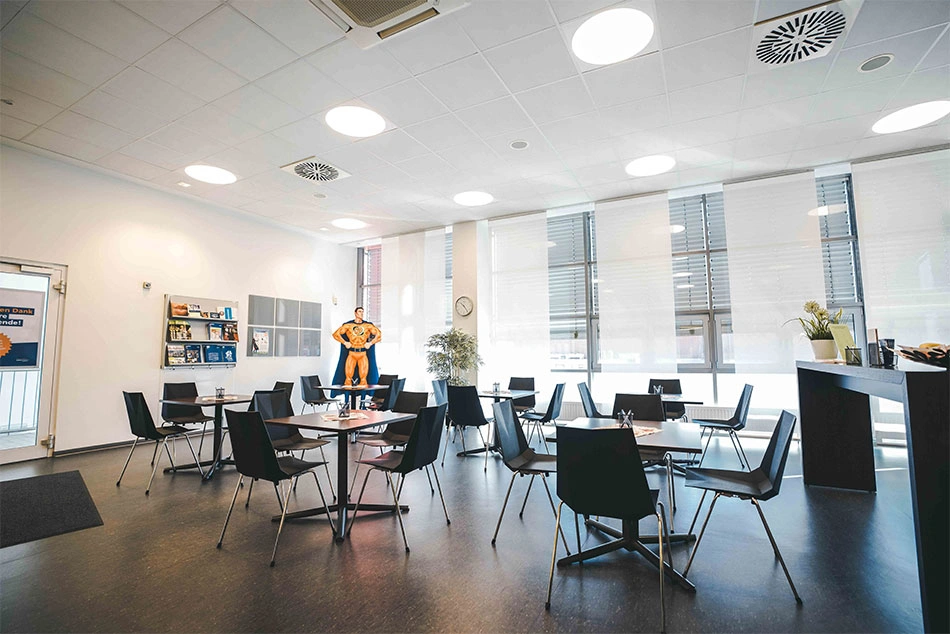 Ein Warteraum mit Tischen und Stühlen in einem Plasmaspendezentrum.