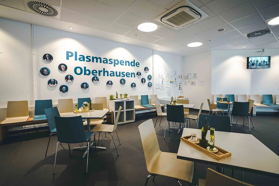 Ein Warteraum mit Tischen und Stühlen in einem Plasmaspendezentrum in Oberhausen.