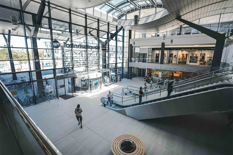 Die Einganghalle einer Bahnhofpassage mit einer Rolltreppe.